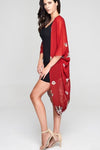 Model wearing red chiffon kimono with floral prints facing left